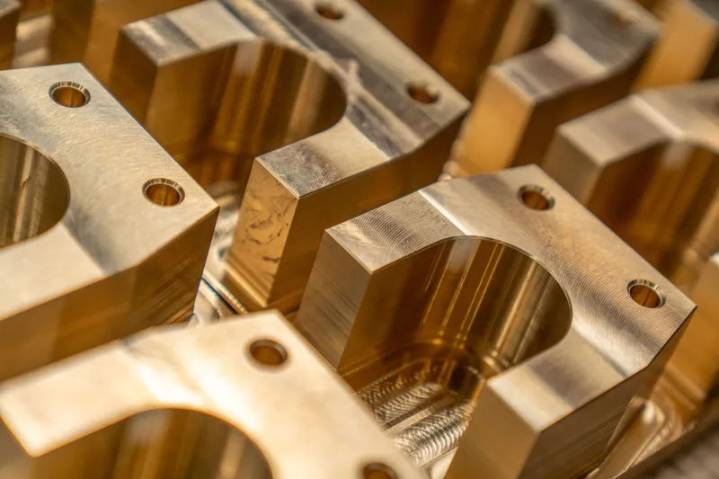 Machined brass components with bores and drilled mounting holes