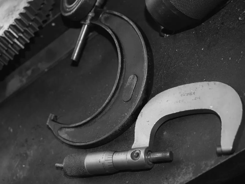 Precision micrometers laid out on a dark workbench